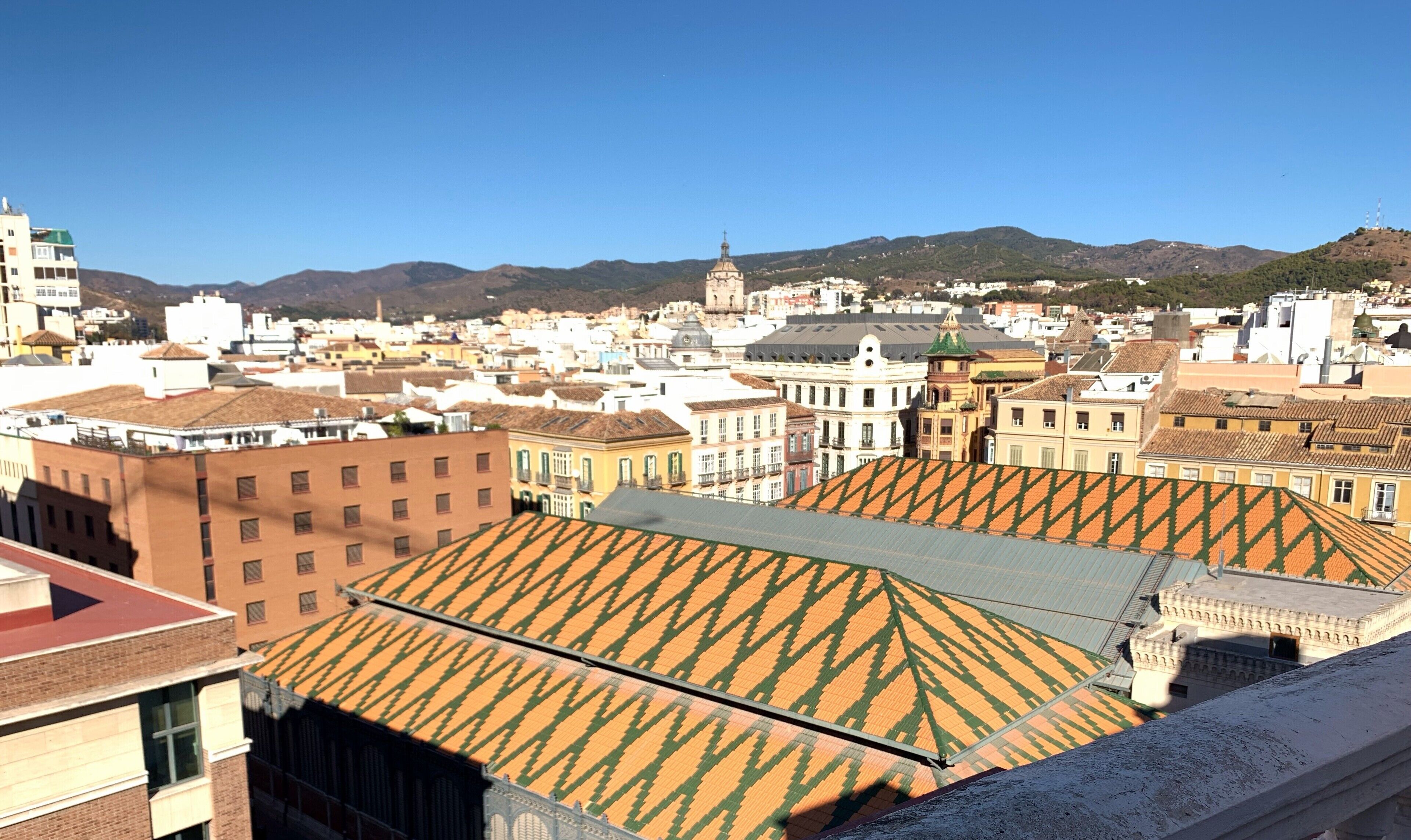 A cityscape with a prominent church and a hill in the background.