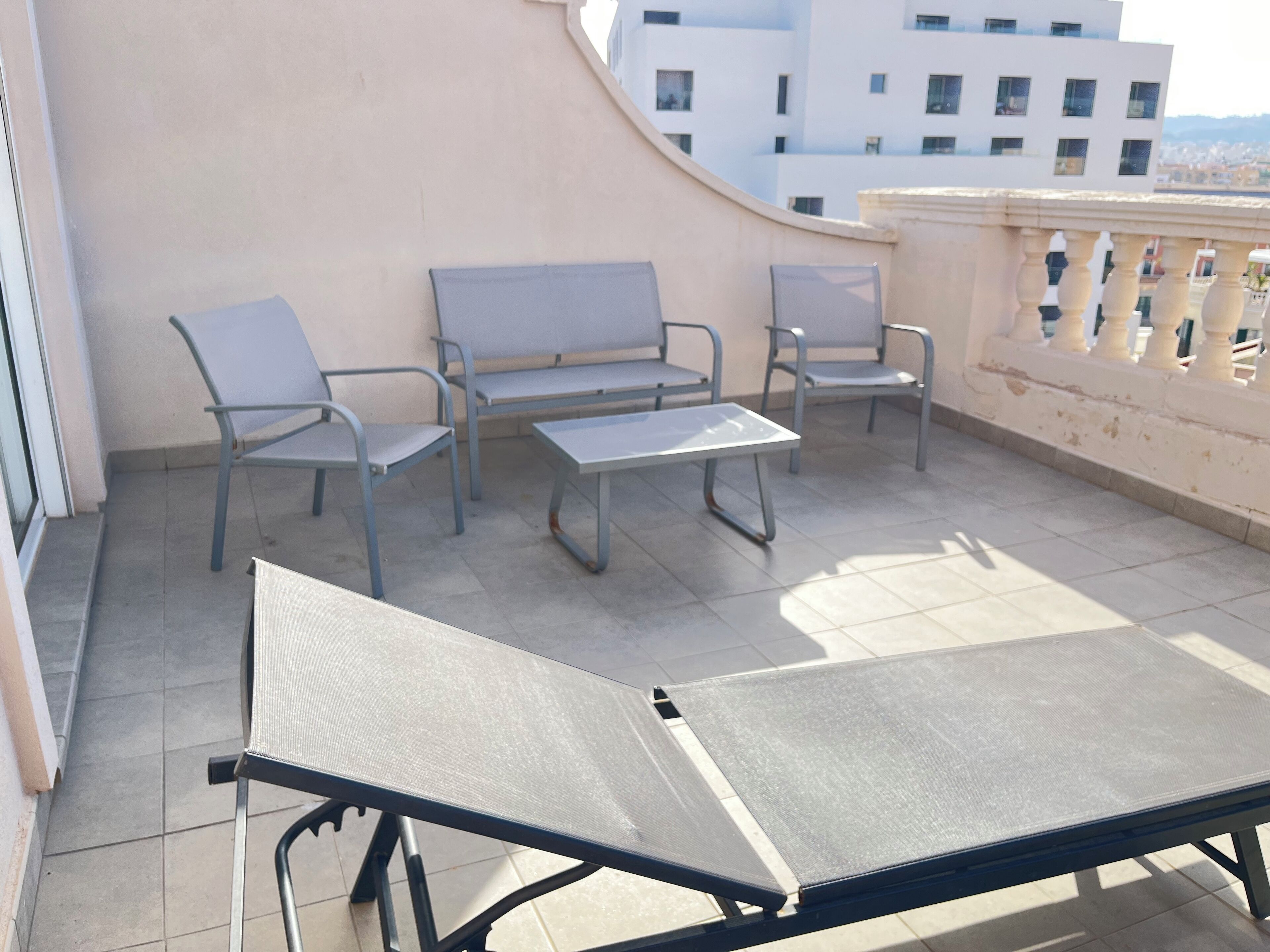 A balcony with a table and two chairs.
