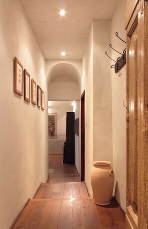 Stylish hallway with framed artwork, a ceramic pot, and a wooden cabinet.