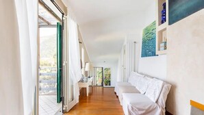 Ein heller Flur mit Holzboden, einem weißen Sofa und einem Tisch mit einer Lampe.