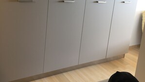 A room with a large grey wardrobe, a wooden floor, and a black bag on the floor. - Empuriabrava apart. First line of the sea, central, Wifi, Air conditioning.  (Empuriabrava)