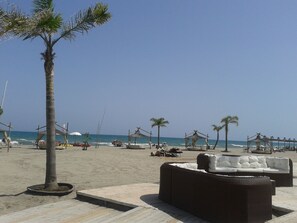 A beachside lounge with outdoor seating and palm trees. - Secluded garden in a typical Southern Italy's house in villa-Fireplace&freeWiFi (Potenza)
