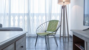 Una habitación con una cama, una lámpara y una silla.