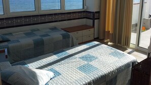 A bedroom with two beds, a small desk, and a view of the sea through large windows. - House on the Mediterranean, swimming pool, BBQ Garden, WiFi, air conditioning (Rincon de la Victoria)