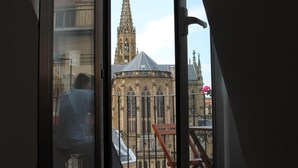 A room with a large window overlooking a historic building with a spire. - Apartment overlooking the cathedral, terrace, wifi, parking included (Donostia)