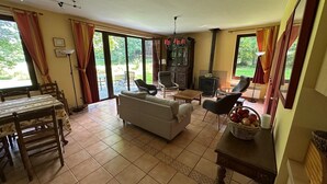 A spacious living area with a sofa, chairs, a dining table, and a fireplace.