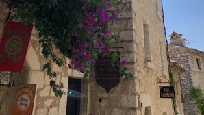 A historic building with a stone facade, a plaque indicating it is a historical view, and a sign for 'AUX BONBONS'. - CHARMING VILLA 💖Panoramic views of sea & mountain, private sunny terraces, pool (Saint-Paul-De-Vence)