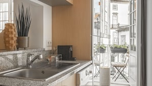 Una cocina moderna con armarios de madera, encimeras de granito y horno empotrado.