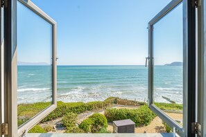An open window with a view of the ocean and a small building in the foreground. - As seen on TV! Luxurious Beach Front Cottage with Hot Tub, Log Burner & Sea Views (Charlestown)