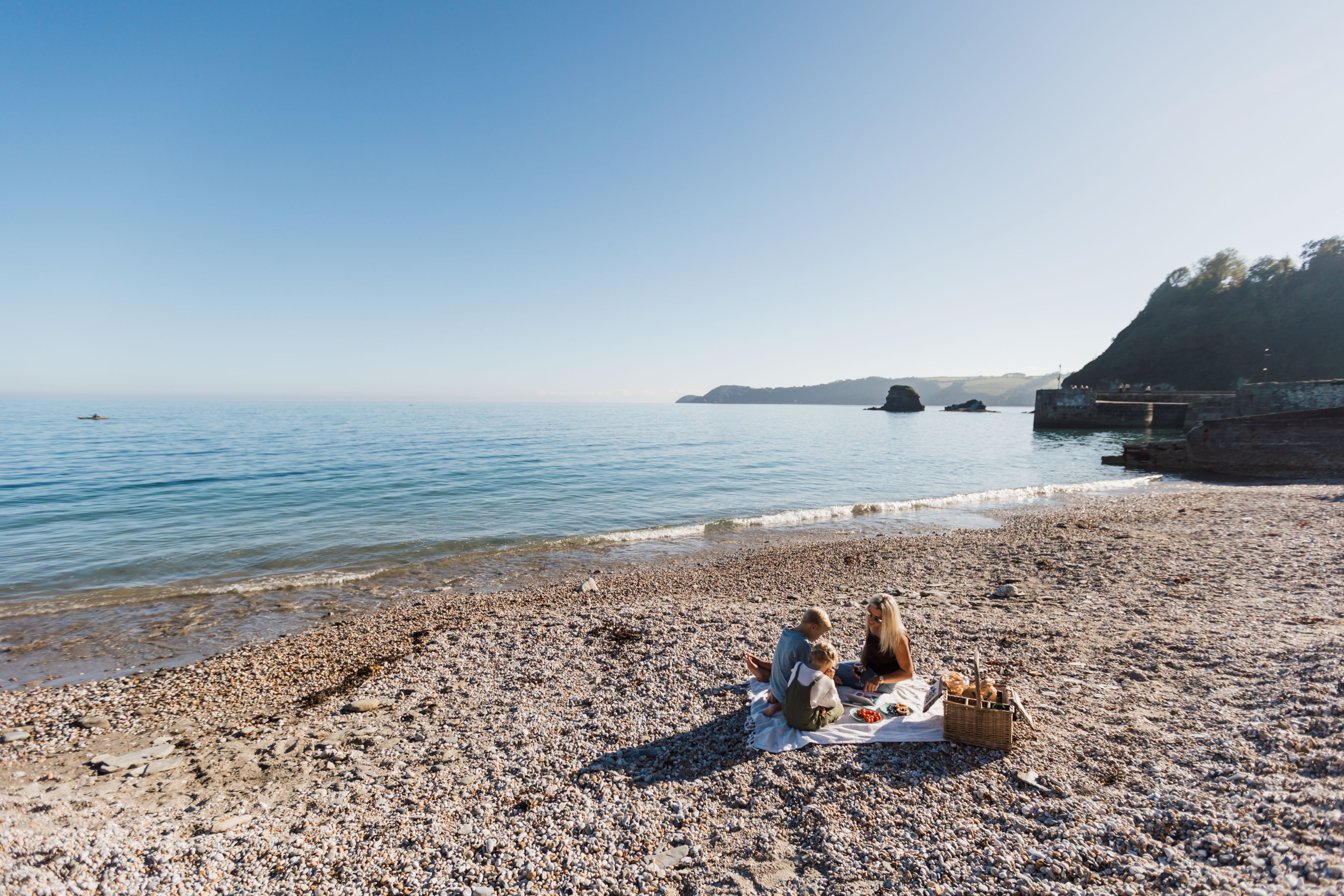 A pebble beach with a picnic setup.