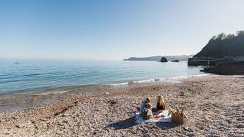 A pebble beach with a picnic setup.