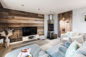 Una sala de estar moderna con un televisor de pantalla plana, una chimenea y un espacio de estar acogedor.