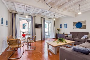 Una sala de estar moderna con un sofá, una mesa de centro y una zona de comedor con sillas.