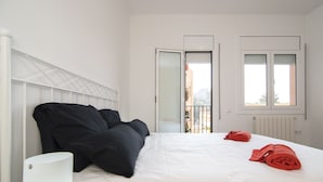 Une chambre d’hôtel avec un lit, une table de chevet, une lampe et une fenêtre donnant sur l’extérieur.