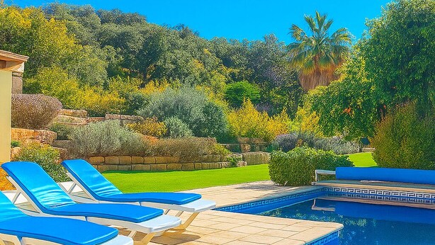 A pool area with lounge chairs and a stone deck. - wonderful villa with beautiful view of the mountains  (Estoi)