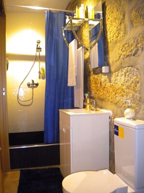 Une salle de bain avec une douche, un lavabo et des toilettes.