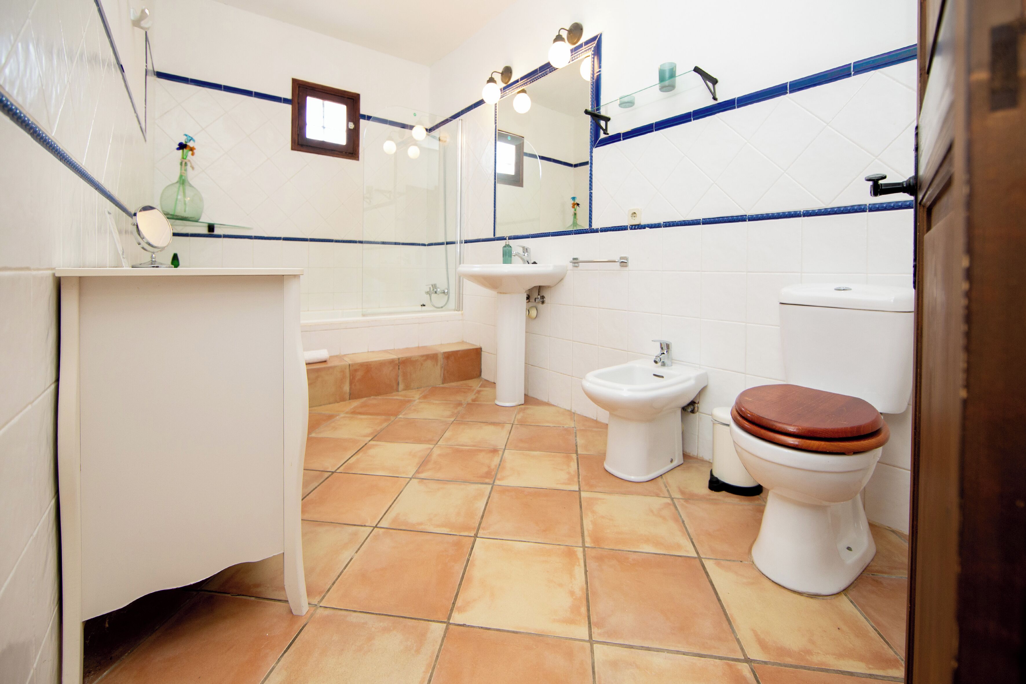 A bathroom with a bathtub, a sink, a bidet, and a toilet.
