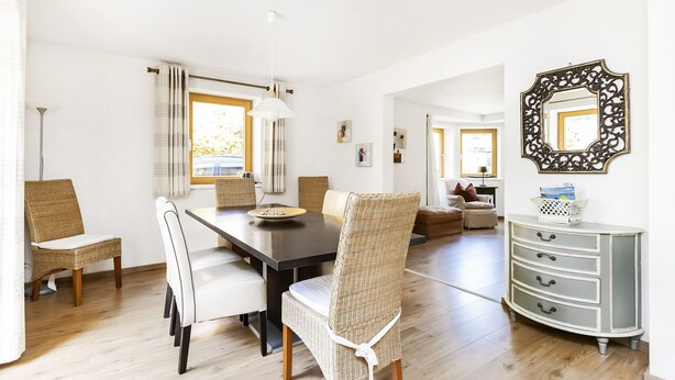 A dining area with a dark wooden table, wicker chairs, and a white pendant light. - Chalet Struber - Luxury 3 Bedroom Villa In The Centre Of Zell (Zell am See)