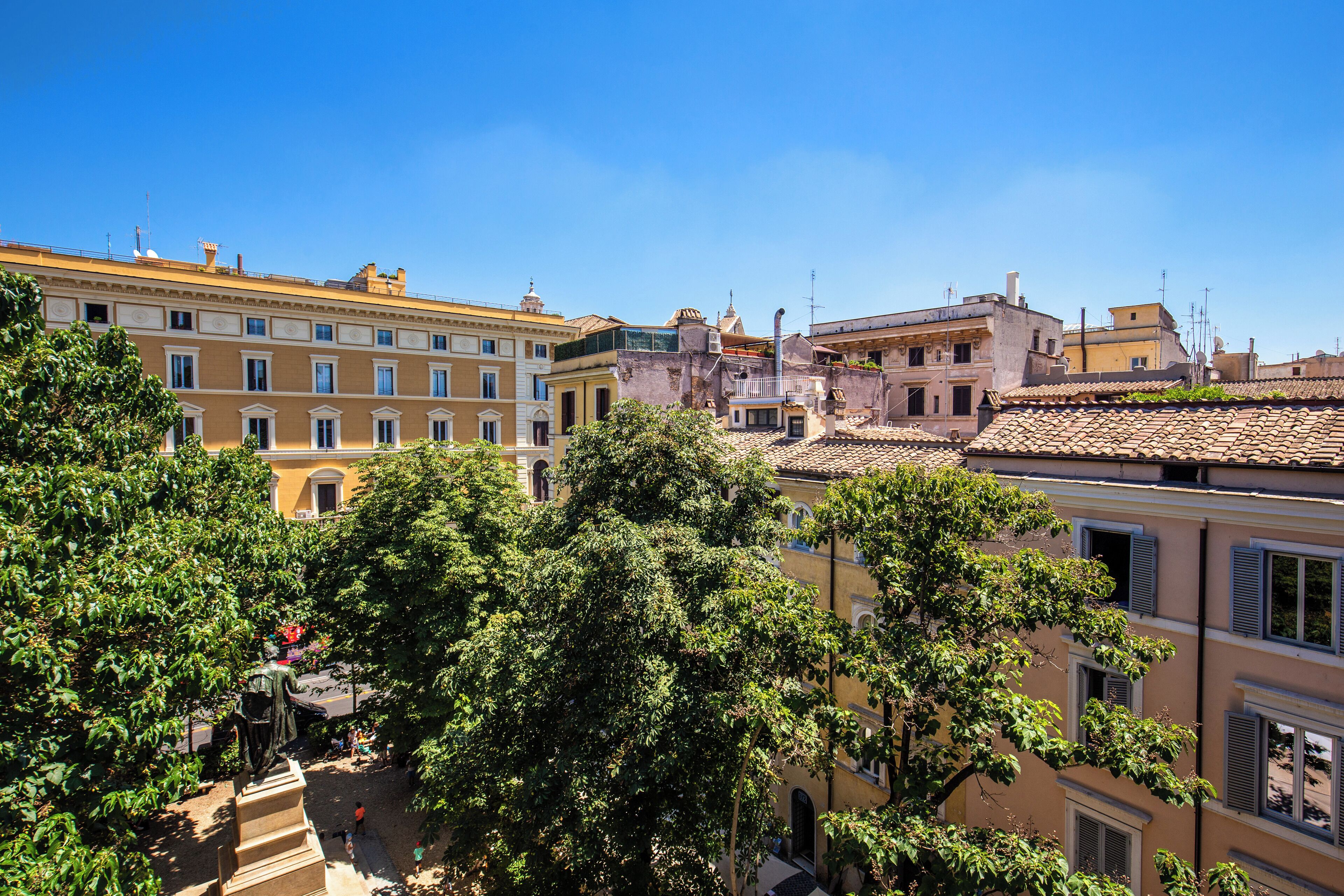 A historic building with multiple stories, classic architecture, and a courtyard with trees.