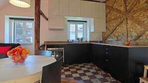 Eine moderne Küche mit schwarzen Schränken, einem Schachbrettboden und einem großen Fenster.