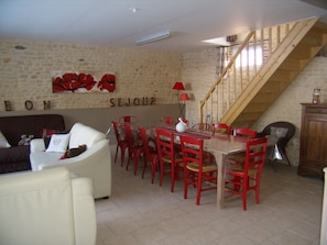 A dining area with a wooden staircase, a stone wall, and a red table with chairs. - Mansion - Fourches (Fourches)