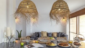 A modern living room with a glass coffee table, a sofa, and a dining area with a buffet. - Brand New Top Luxury Villa!  Stunning modern, extremely stylish. (Afandou)