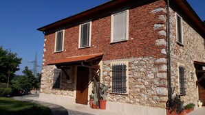 A two-story building with a stone facade and multiple windows with shutters. - Rustic first hill sea view in Versilia (Pietrasanta)