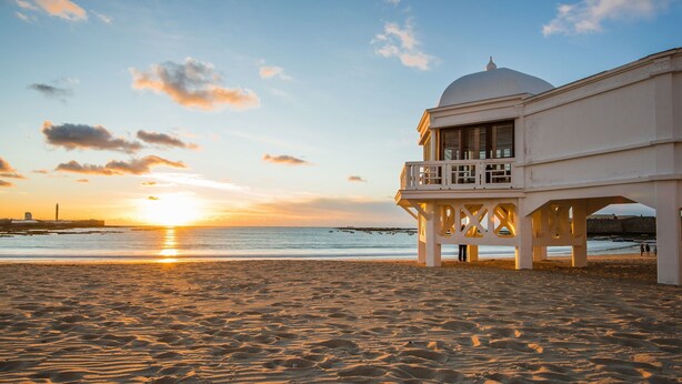 A beach with a white building featuring a balcony and a dome. - 4th floor apartment in historic Cadiz, and just a 10 minutes walk to the beach. (CADIZ)