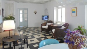 A room with a checkered floor, a television, wicker furniture, and a lamp. - 4th floor apartment in historic Cadiz, and just a 10 minutes walk to the beach. (CADIZ)