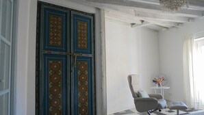A room with a large blue door, a modern chair, a small table with a vase, and a chandelier. - 4th floor apartment in historic Cadiz, and just a 10 minutes walk to the beach. (CADIZ)