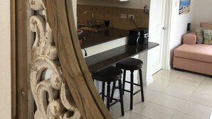 A kitchen with wooden cabinets, a black countertop, and two stools.
