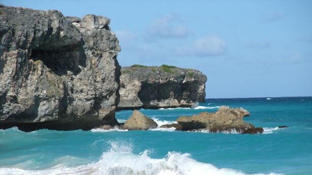 A coastal scene with rocky cliffs and turquoise waters.