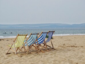 Beach chairs lined up on the sand facing the sea. - Breath Taking Views - Sea Breeze -  A Holiday Home on the shore of Poole Harbour (Poole)