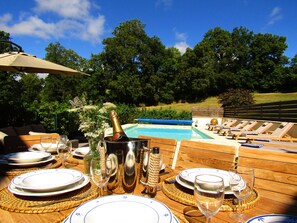 Enjoy a meal with a view of the pool and lush surroundings.