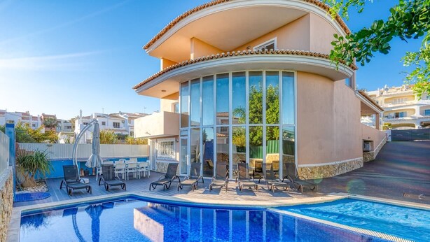 A modern house with a swimming pool, outdoor seating, and a large glass door. - Full private villa - 300sqm Hammam Jacuzzi Heated Pool Billiard BBQ - Ideal & quiet location (Albufeira)