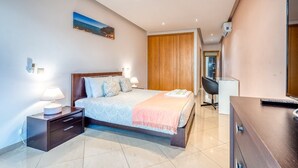 A modern bedroom with a bed, bedside tables, a desk, and a wardrobe. - Full private villa - 300sqm Hammam Jacuzzi Heated Pool Billiard BBQ - Ideal & quiet location (Albufeira)