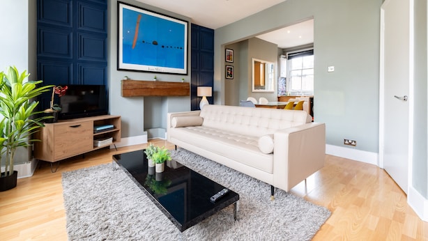 Ein modernes Wohnzimmer mit Sofa, Couchtisch und Fernseher.