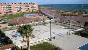 Ein Basketballplatz, Palmen und der Blick auf den Ozean.