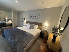 Relax in a spacious bedroom with a large bed, bedside table, and comfortable chair.