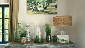 A wooden dresser with decorative items including a painting, a lamp, and various vases. - Local stone Provencal country cottage with pool  (Saint-André-De-Roquepertuis)