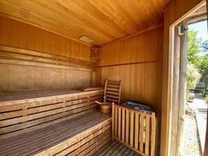 Una sauna de madera con bancos y una escalera.