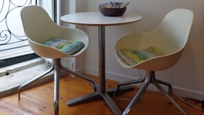 A small room with two chairs, a round table, and a decorative fan on the wall. - Best in Alfama - Free pick up (Lisboa - Alfama)