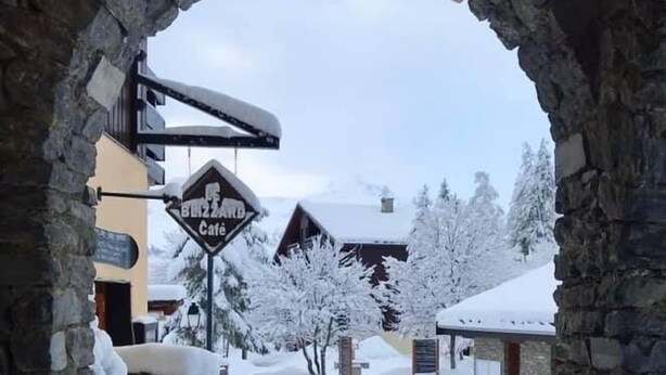 Ein verschneiter Weg, der zu einem Gebäude mit einem steinernen Bogen führt.