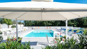 A swimming pool with lounge chairs and umbrellas. - Cascina Marianna 12+4, Emma Villas (Fossombrone)