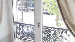 A window with a view of a street and parked cars outside.