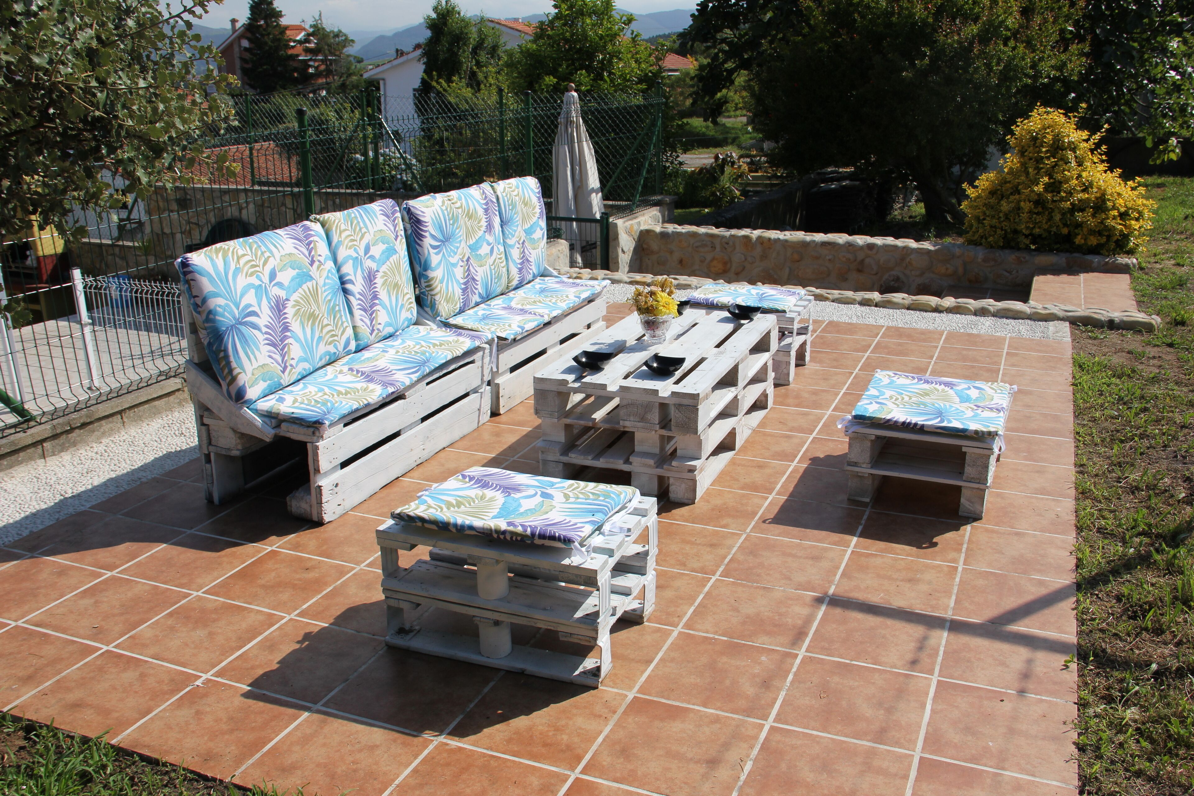Un patio al aire libre con un conjunto de sofás y dos mesas.