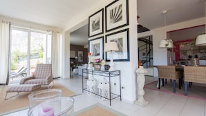 A spacious living area with a dining table, chairs, a sofa, and a coffee table. There is a staircase leading to another level, and a kitchen area is visible in the background. - Villa between sea and mountain with private pool and sea view with private pool  (Capaci)