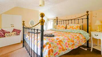 A bedroom with a bed, a bedside table, a wardrobe, and a ceiling fan.