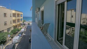 A balcony with a view of the street and buildings. - Archimedes Lounge in Cefalù (Cefalù)