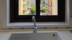A bathroom with a window overlooking a residential area. - Archimedes Lounge in Cefalù (Cefalù)